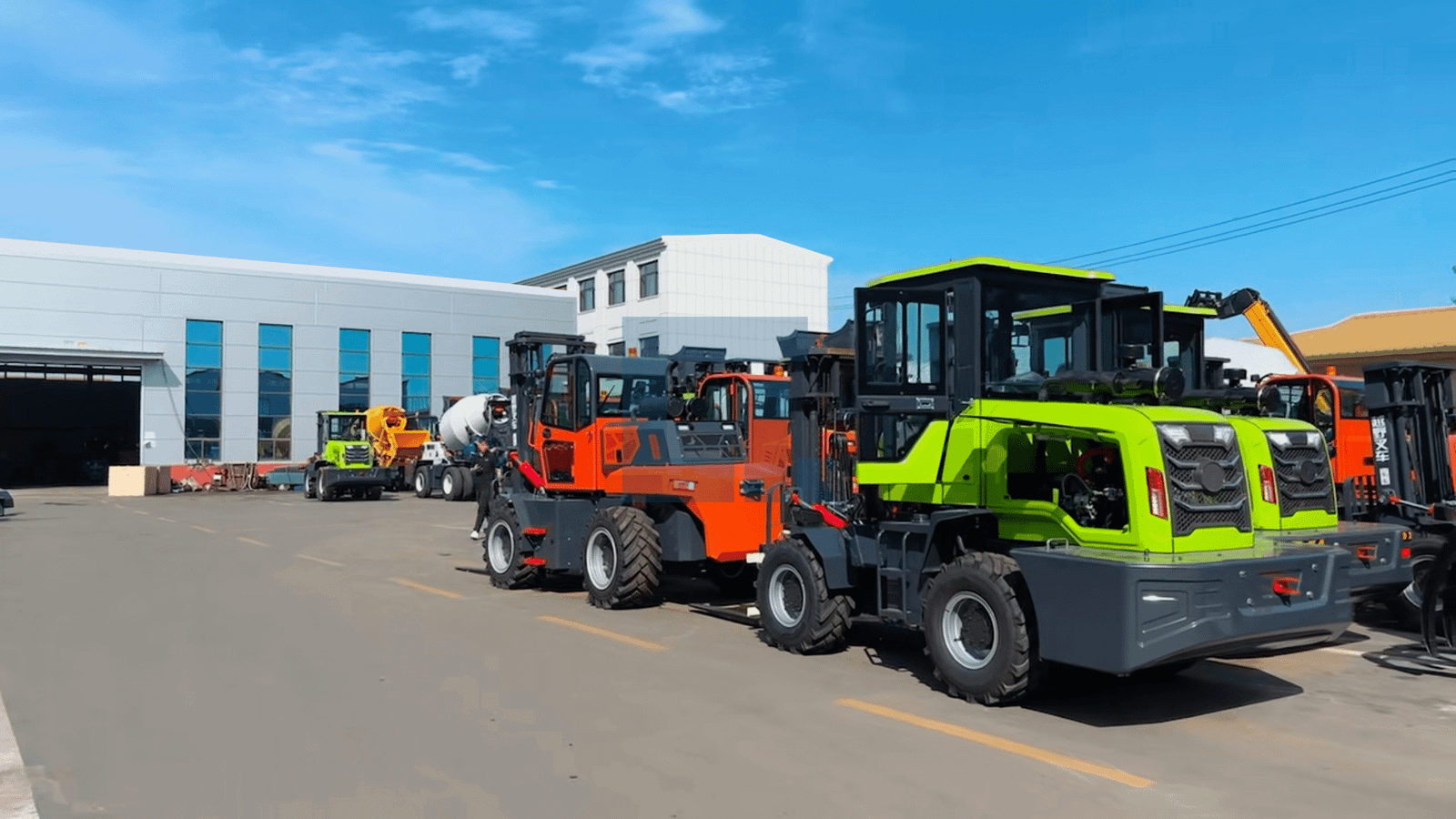 HIGHLAND HEAVY MACHINERY green and orange rough terrain forklifts lined up in front of the factory, showcasing flagship product lineup and brand manufacturing strength on the Home page.