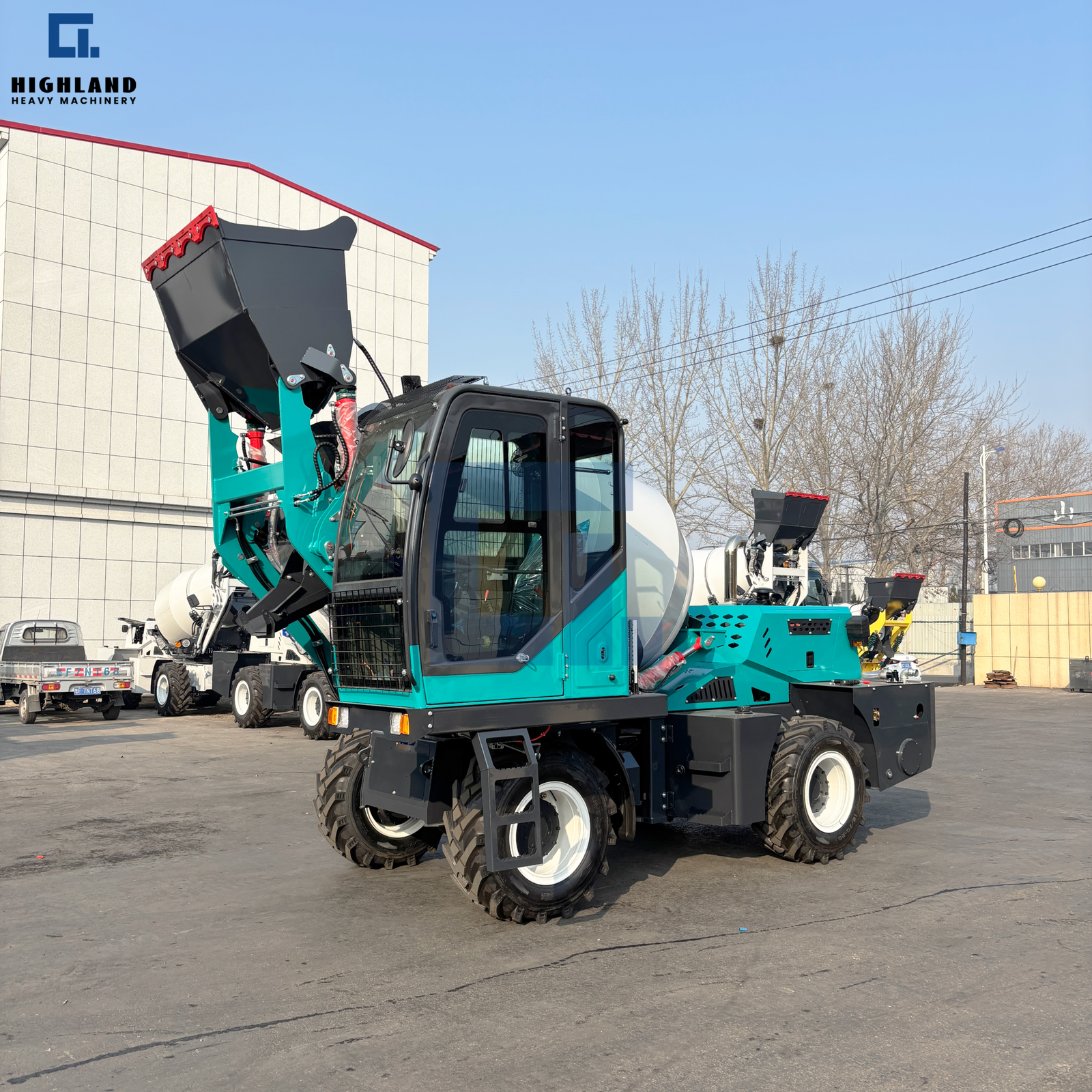 HIGHLAND HEAVY MACHINERY teal and black 2.6m³ self loading concrete mixer truck with a white mixing drum, shown in front three-quarter view with the loading hopper raised, positioned in the factory yard alongside other mixer trucks for fleet staging and export readiness.