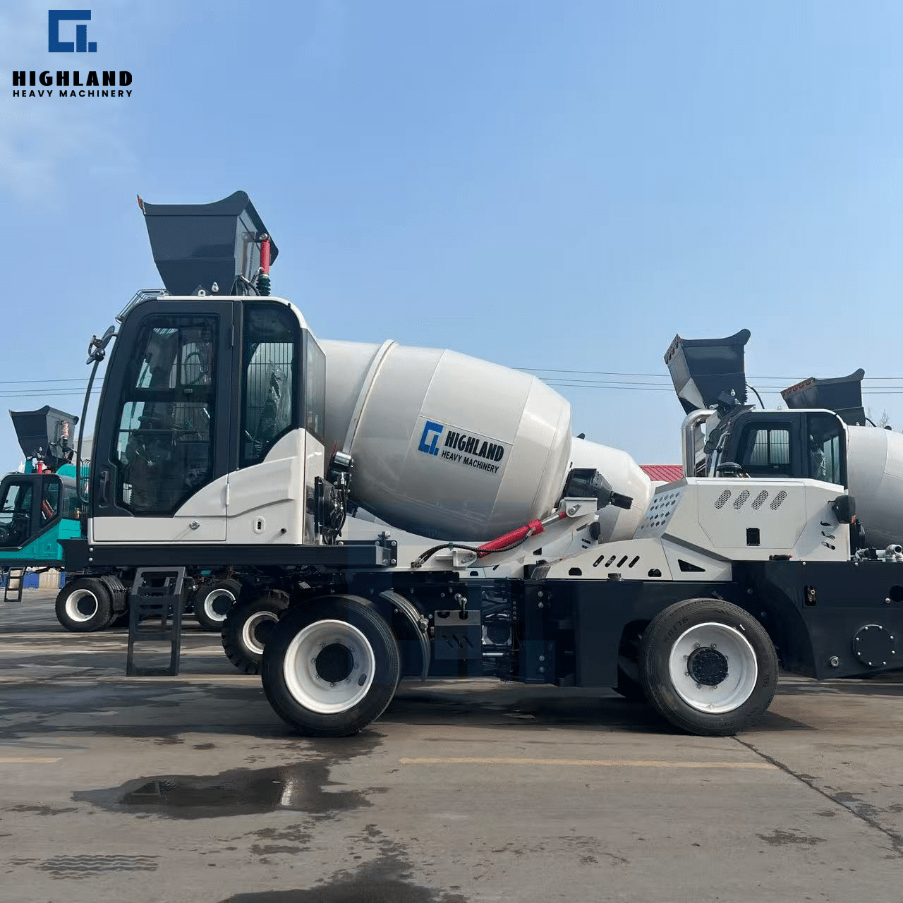 HIGHLAND HEAVY MACHINERY white and black self loading concrete mixer truck with a raised loading hopper, featuring a black mixing drum and heavy-duty chassis, parked in an outdoor factory yard ready for global delivery.