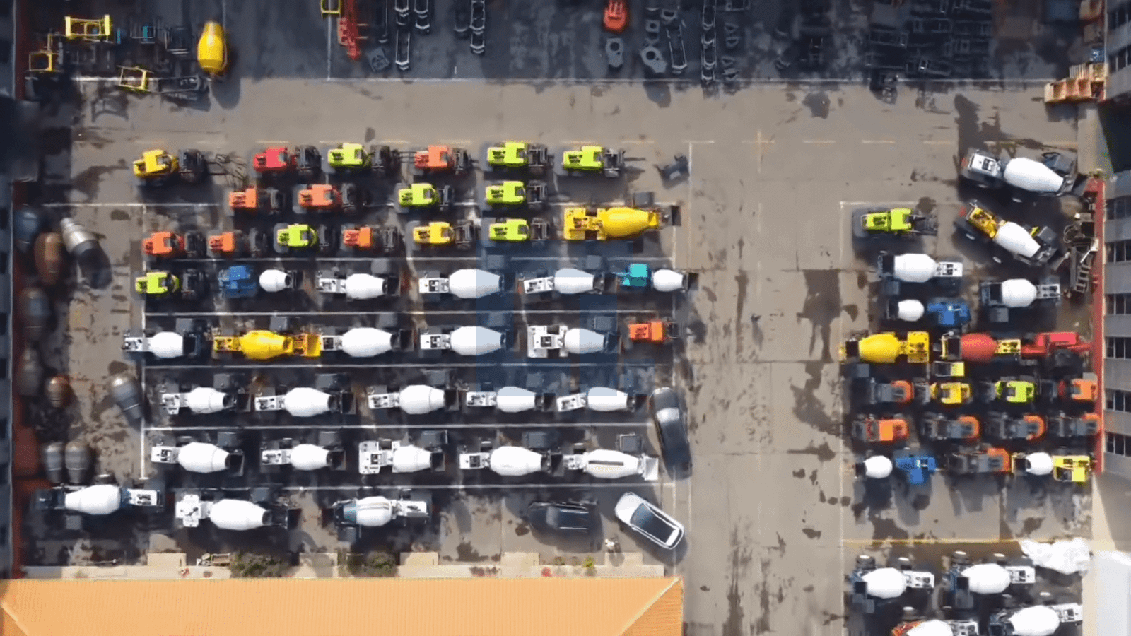 Aerial view of HIGHLAND HEAVY MACHINERY's massive equipment storage yard, with hundreds of self loading concrete mixer trucks and rough terrain forklifts lined up in organized rows, showcasing large-scale production capacity and ready inventory for global export.