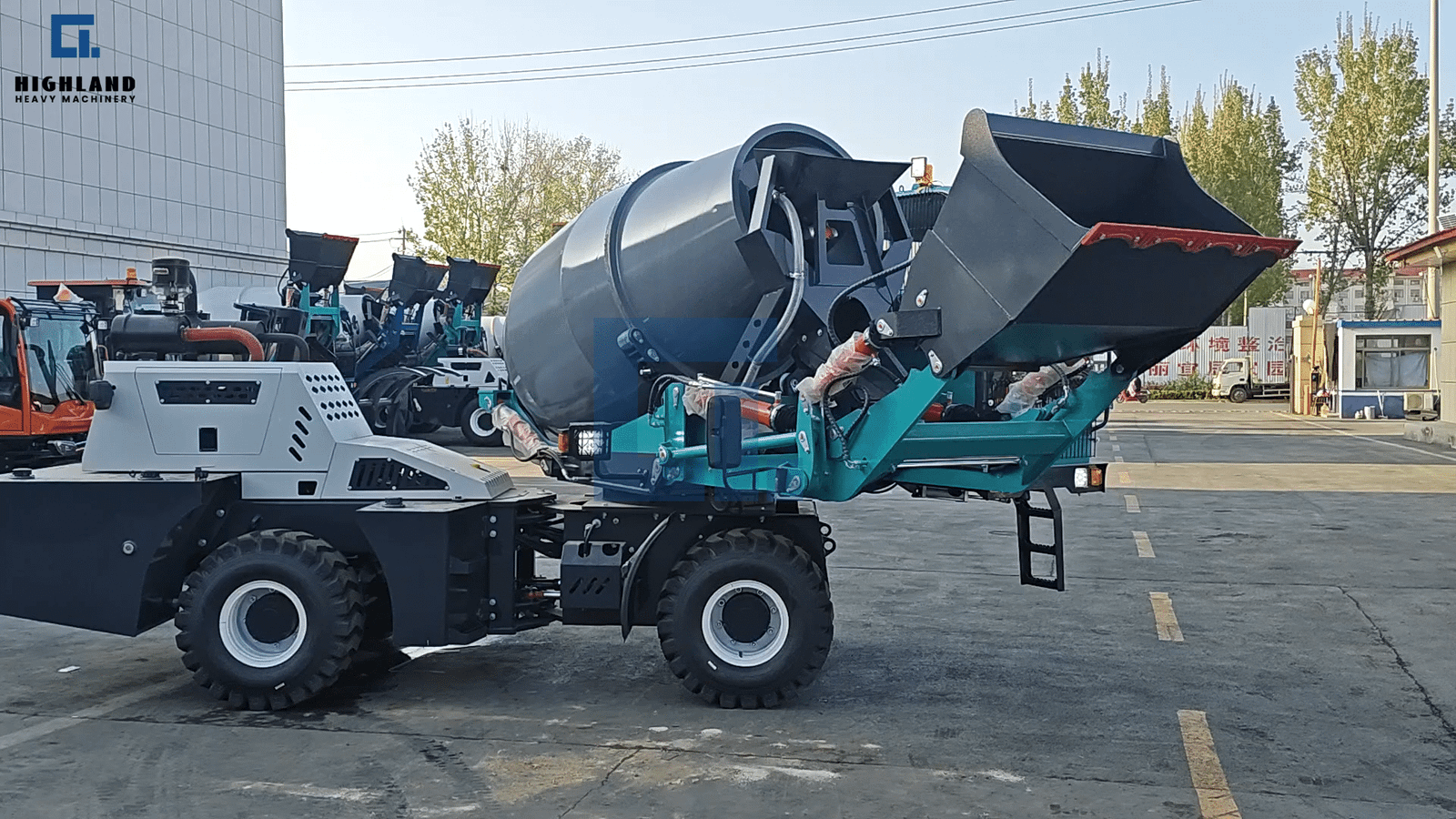HIGHLAND HEAVY MACHINERY teal 2m³ self loading concrete mixer truck with raised bucket featuring a red cutting edge, shown in a factory yard with other mixer trucks in the background.