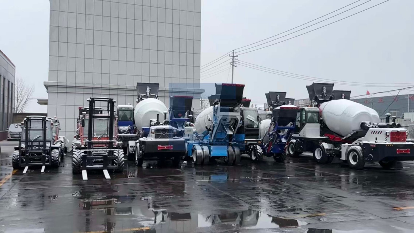 HIGHLAND HEAVY MACHINERY diverse fleet of rough terrain forklifts and self loading concrete mixer trucks parked in a wet factory yard after rain, showcasing a full product lineup ready for global export.