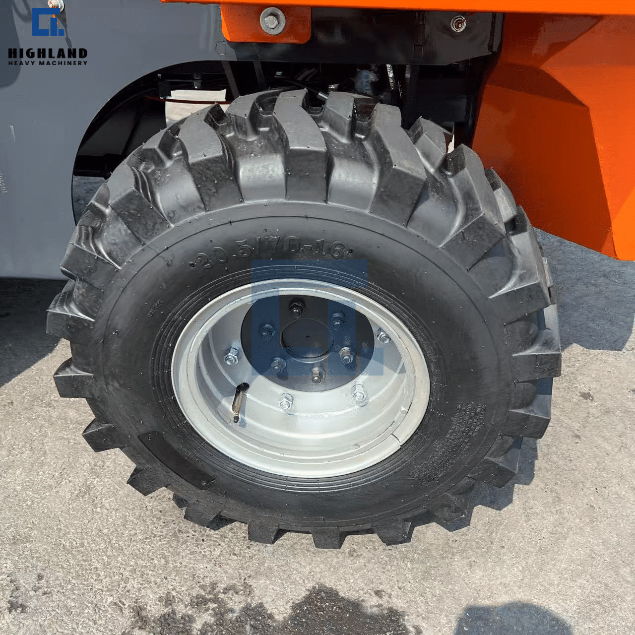 HIGHLAND HEAVY MACHINERY heavy-duty off-road forklift tire and wheel assembly close-up, featuring a deep aggressive tread pattern and a robust steel rim, designed for maximum traction on rugged terrains.