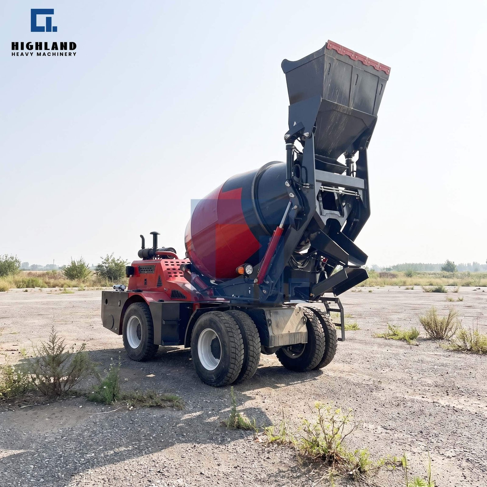 HIGHLAND HEAVY MACHINERY red self loading concrete mixer truck with high-tip bucket raised high, parked on a rugged dirt job site, designed for efficient high-discharge loading and reliable concrete batching.